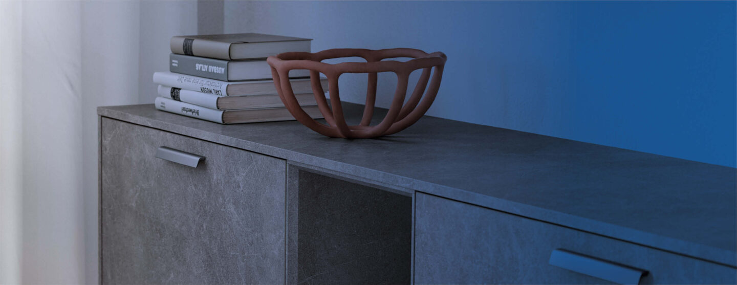 Nauhaufnahme einer granitgrauen Ablagefläche mit Schüssel und Büchern darauf drapiert.