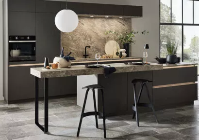 Moderne von nobilia in schwarz mit Granitarbeitsplatte, Kochinsel und Kehlleistenbeleuchtung bei Tischer & Teuber