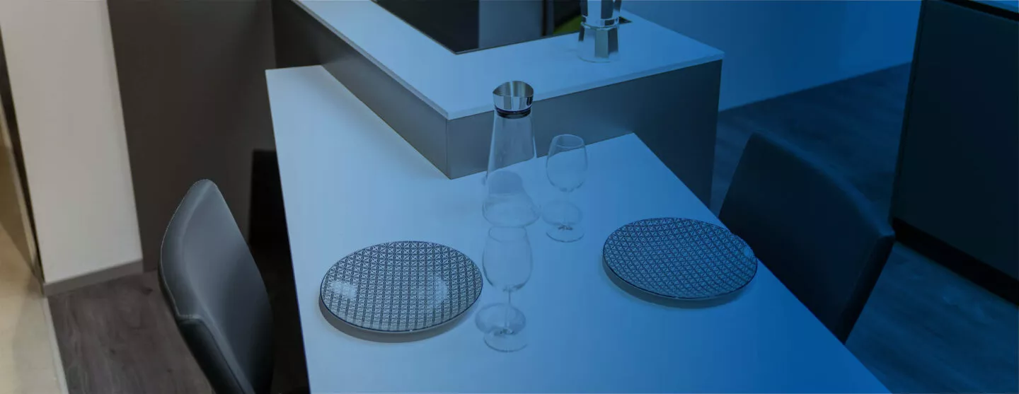 Esstischinspiration im Küchenstudio Tischer & Teuber. Darüber liegt ein blauer Farbverlauf.